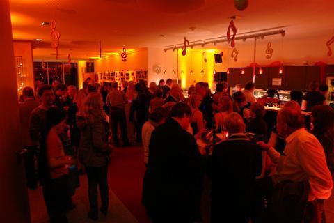 tanzende Paare in einem Hörsaal mit Parkettboden