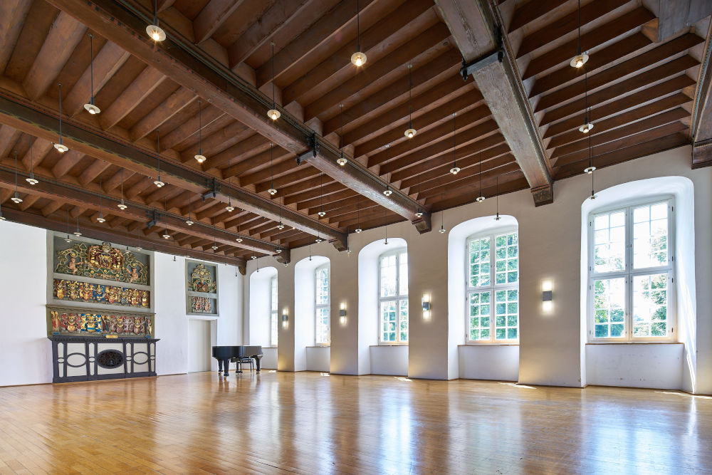 tanzende Paare in einem Hörsaal mit Parkettboden